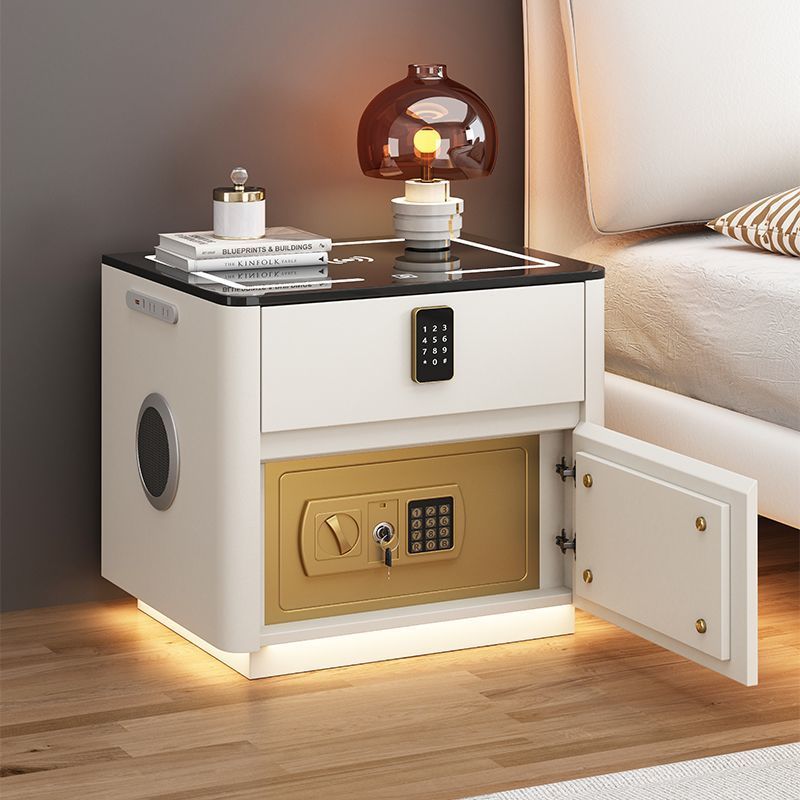 White modern smart nightstand with an open gold digital safe, wireless charging glass top, and built-in Bluetooth speaker by Kouvr.