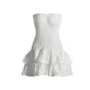 Model wearing the Kouvr Starla white strapless smocked mini dress with a tiered broderie anglaise ruffle skirt