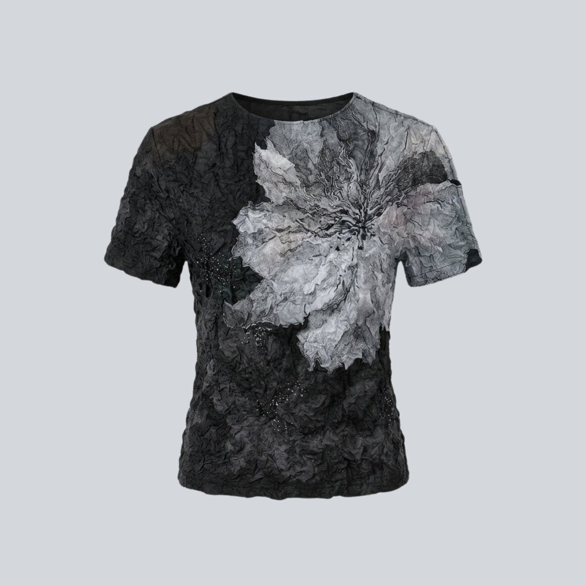 Front flat lay of the Kouvr black short sleeve statement top detailing the crinkled texture and silver embellishments.