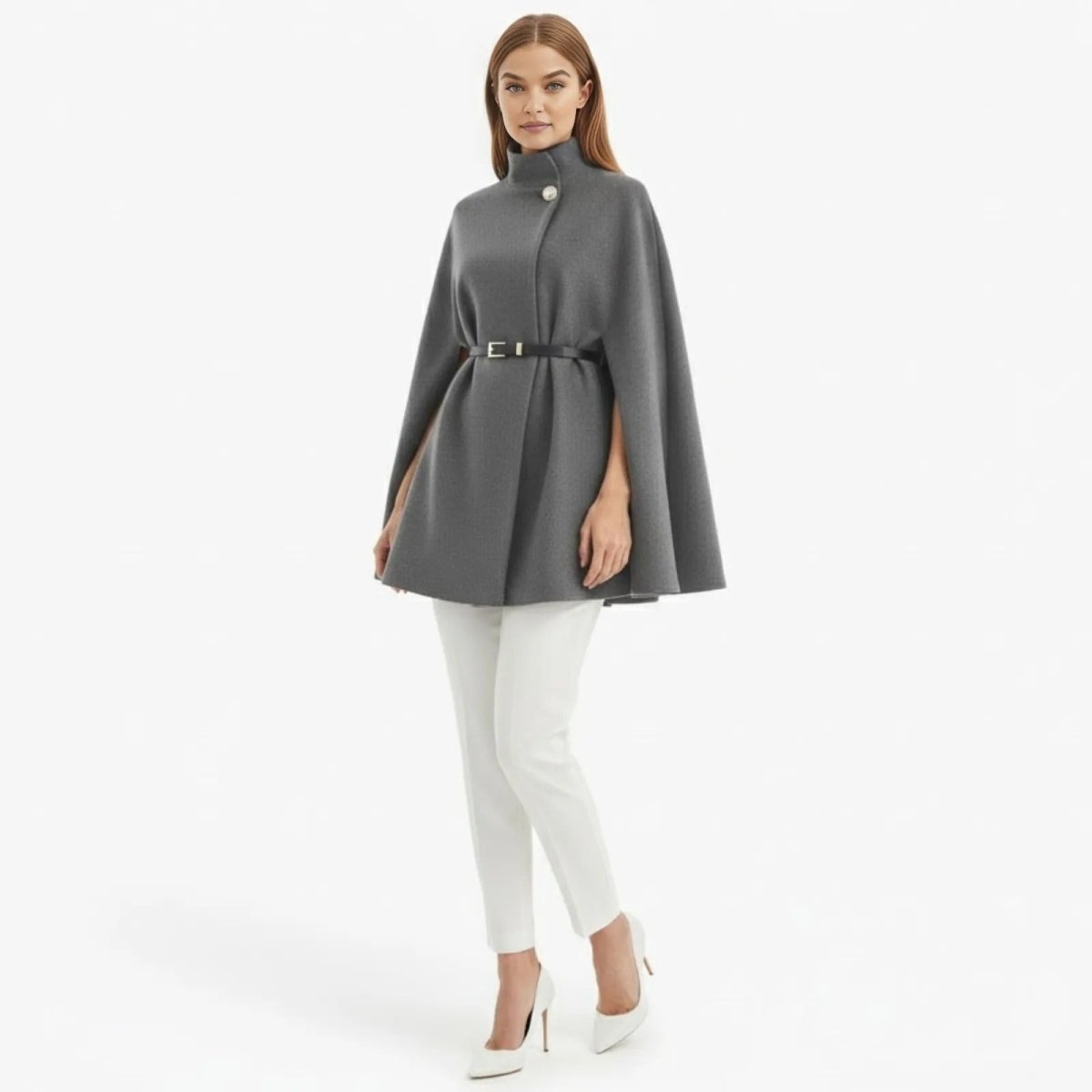 Model wearing the grey high neck belted cape coat from Kouvr Fashion, styled with white trousers.
