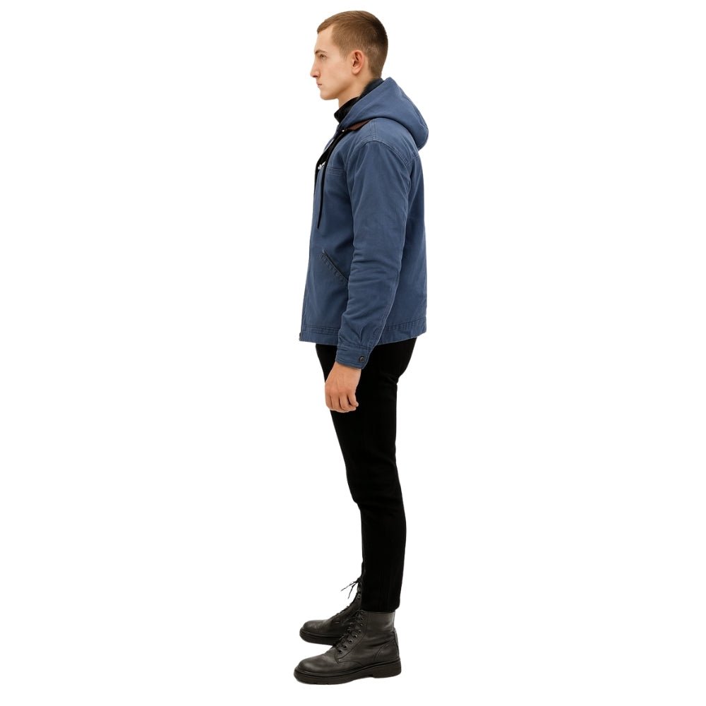Man wearing the Kouvr tyrian sherpa-lined blue canvas hooded jacket, facing side with hands in pockets.