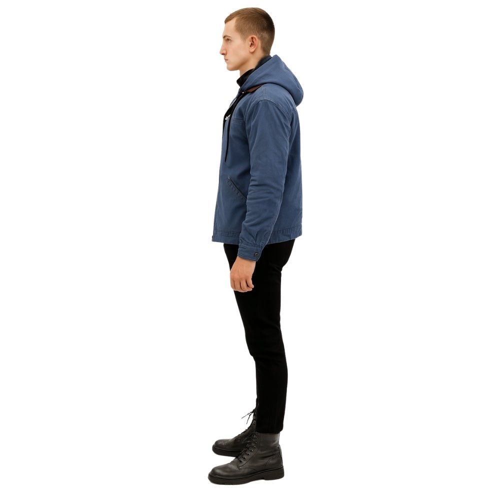 Man wearing the Kouvr tyrian sherpa-lined blue canvas hooded jacket, facing side with hands in pockets.