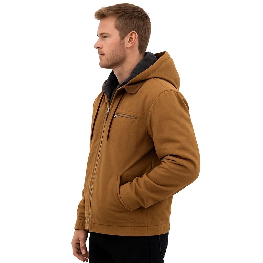 Man wearing the Kouvr tyrian sherpa-lined brown canvas hooded jacket, facing side with hands in pockets.