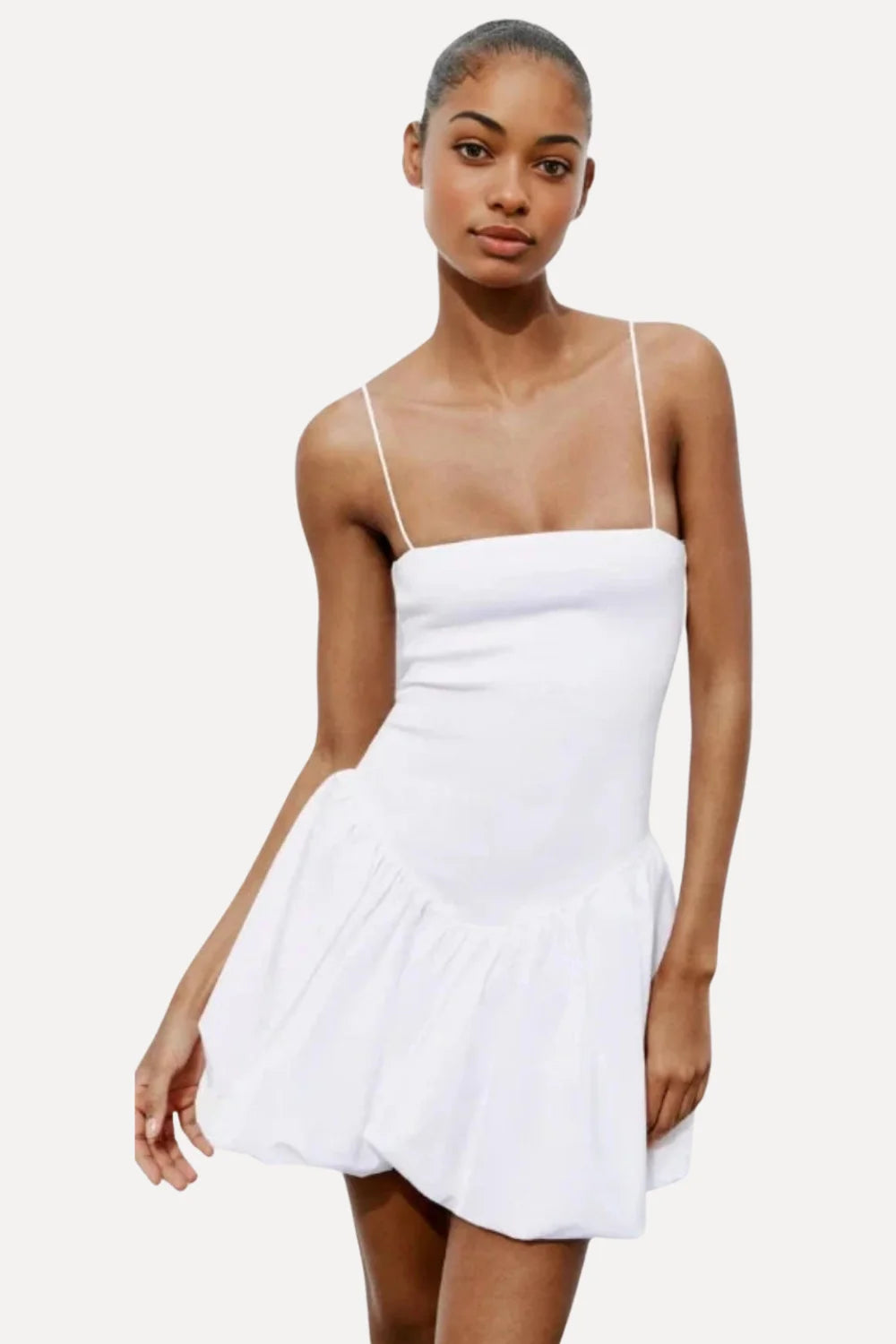 Model wearing the Kouvr white bubble hem mini dress with spaghetti straps