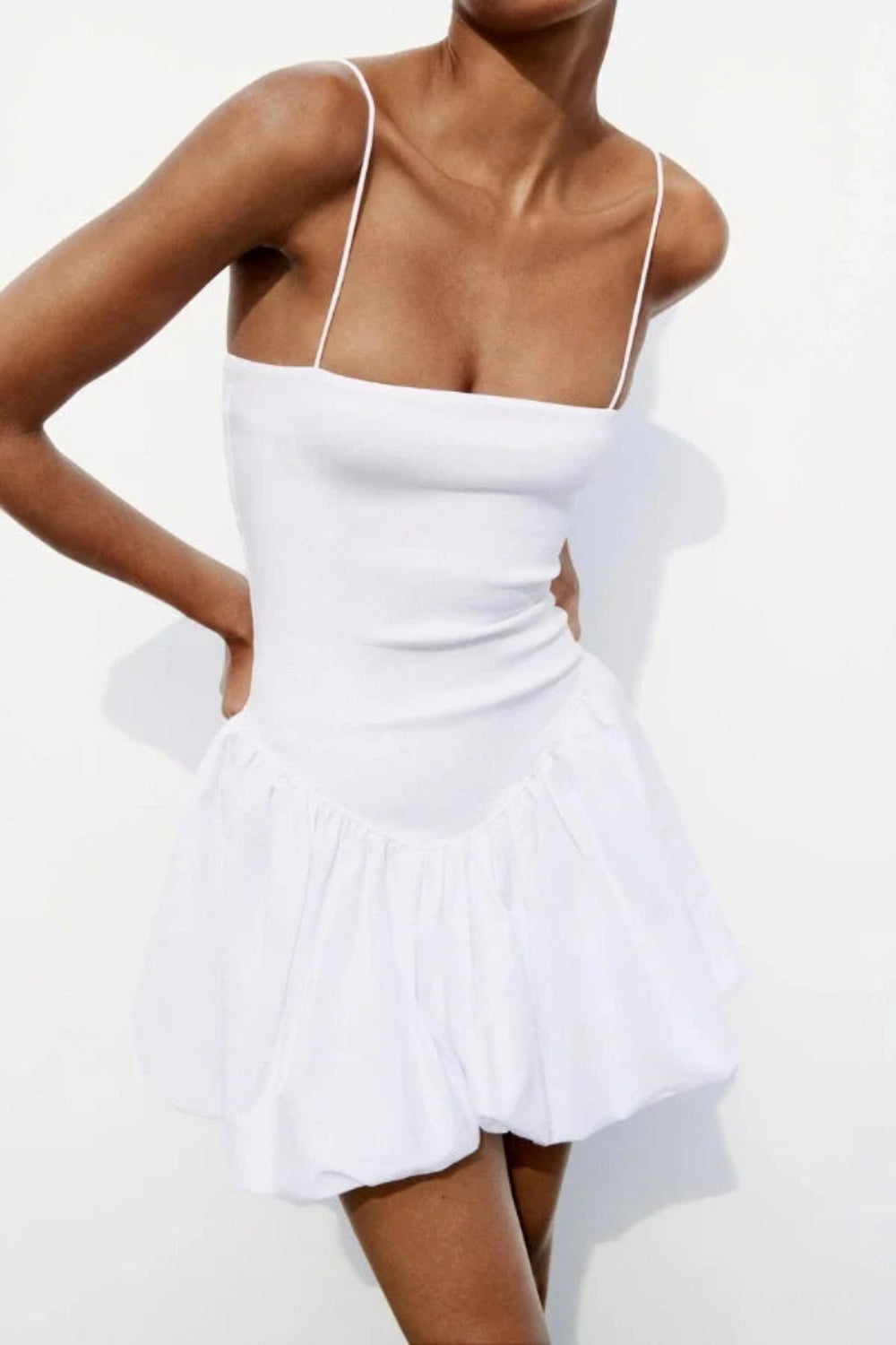 Model wearing the Kouvr white bubble hem mini dress with spaghetti straps