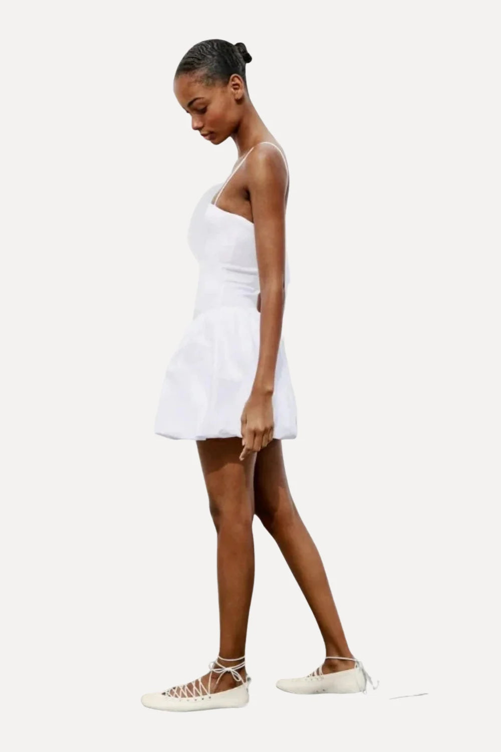 Model wearing the Kouvr white bubble hem mini dress with spaghetti straps