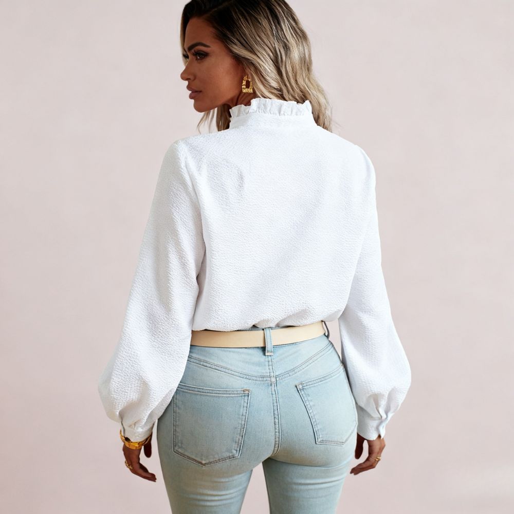 Model wearing the Kouvr women's white textured blouse with ruffle collar, paired with light wash jeans