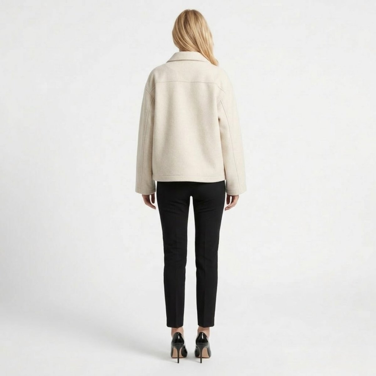 Back view of the Kouvr drop-shoulder white collared jacket highlighting the cropped hip-length hem on a blonde model