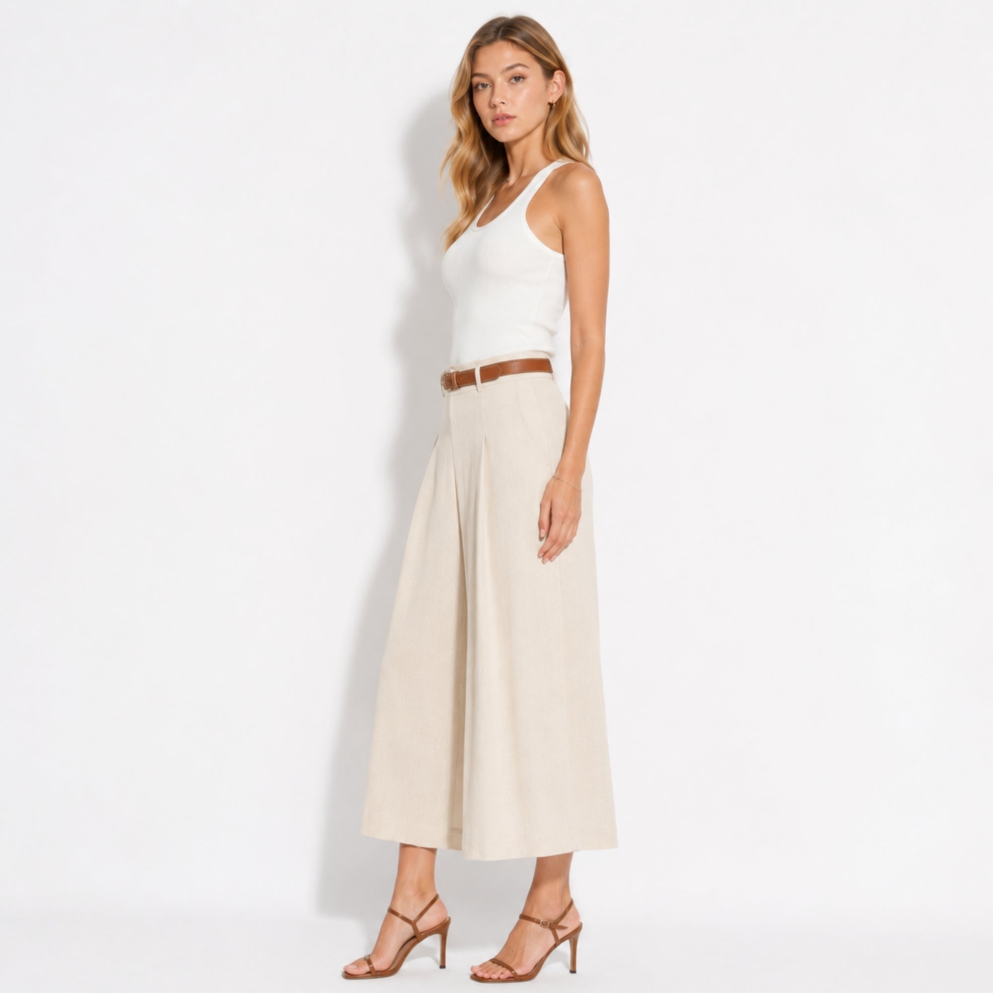 Side profile showcasing the tailored fit and flowy drape of the beige high rise wide leg crop pant.