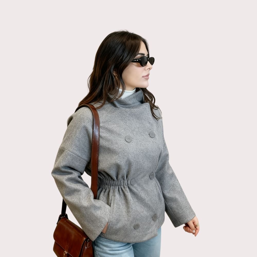 Woman wearing Kouvr's gray wool double-breasted peacoat with a white turtleneck