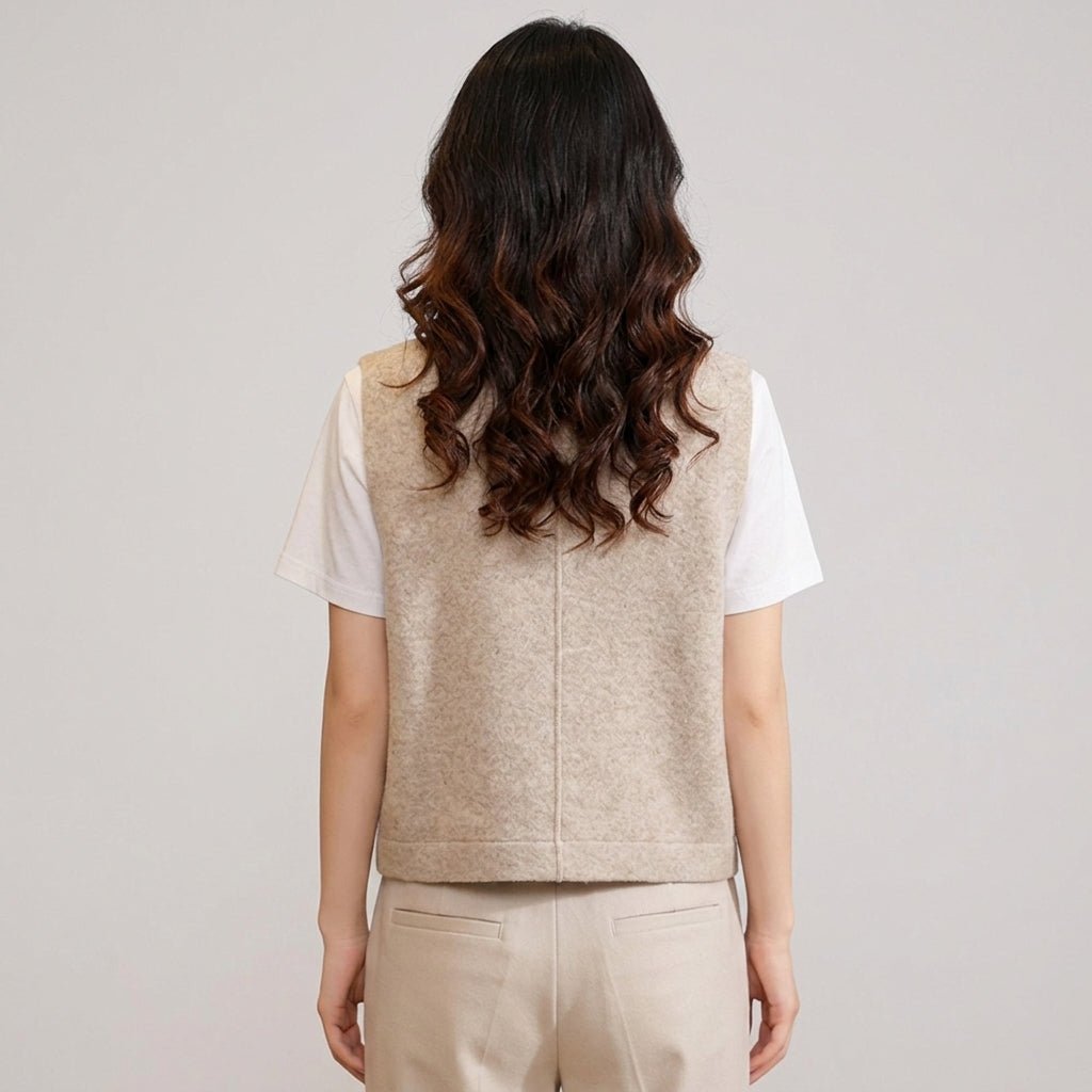 Back view of Kouvr women's heathered beige sleeveless knit waistcoat showing tailored center back seam over a white tee.