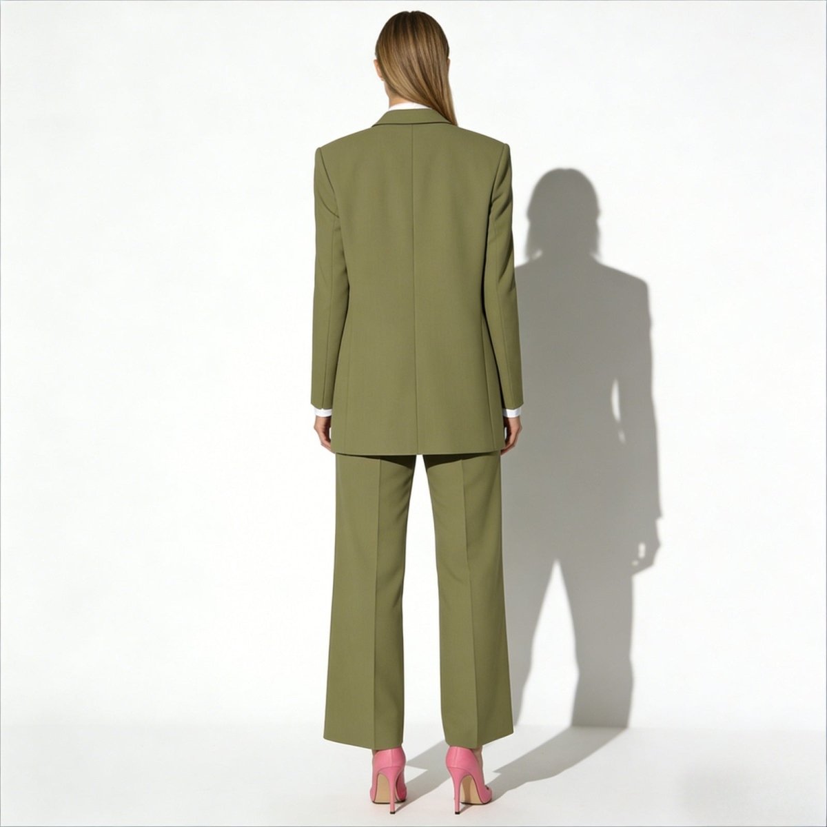 Back view of the Kouvr Fashion olive green suit on a model, highlighting the clean tailoring and structure of the single-breasted blazer.