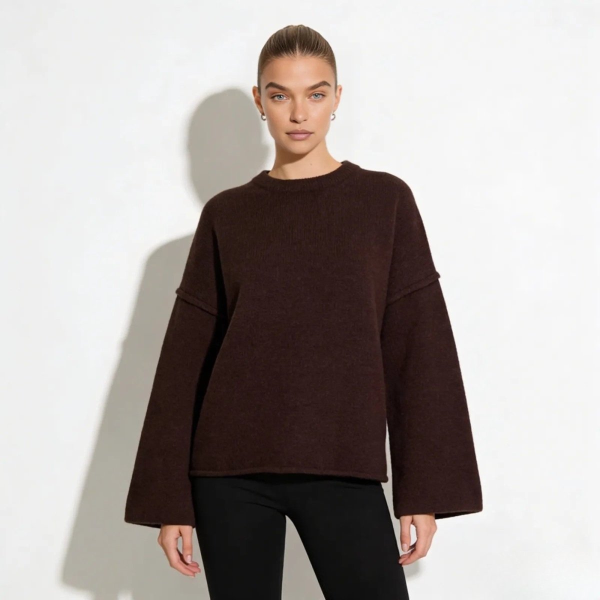 Model wearing the Kouvr oversized boiled wool sweater in dark brown, front view.