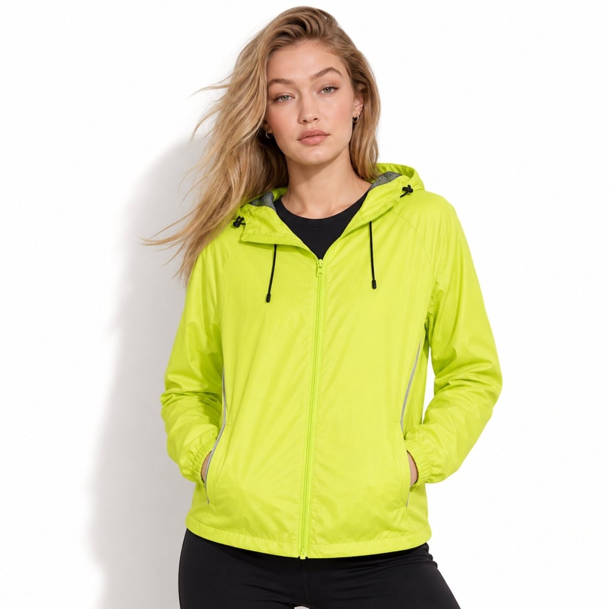 Female model showcasing Kouvr yellow high visibility running jacket with adjustable drawstring hood