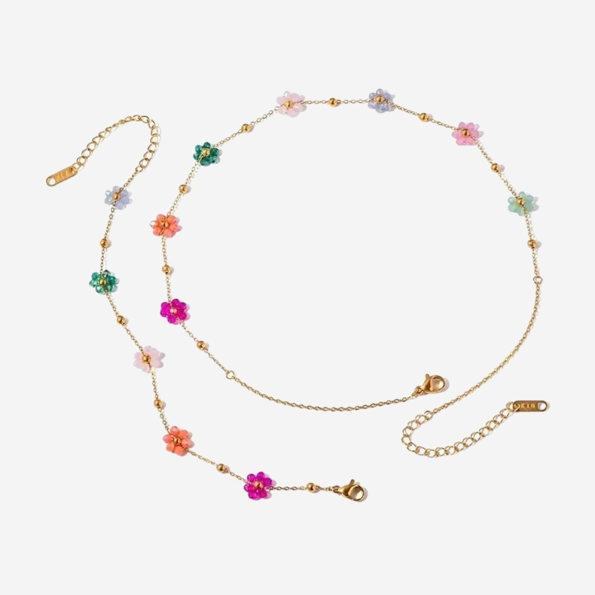 Kouvr Ysabel multicolor beaded flower necklace and matching bracelet laid out on a clean white background, showing the 18k gold chain and lobster clasps.
