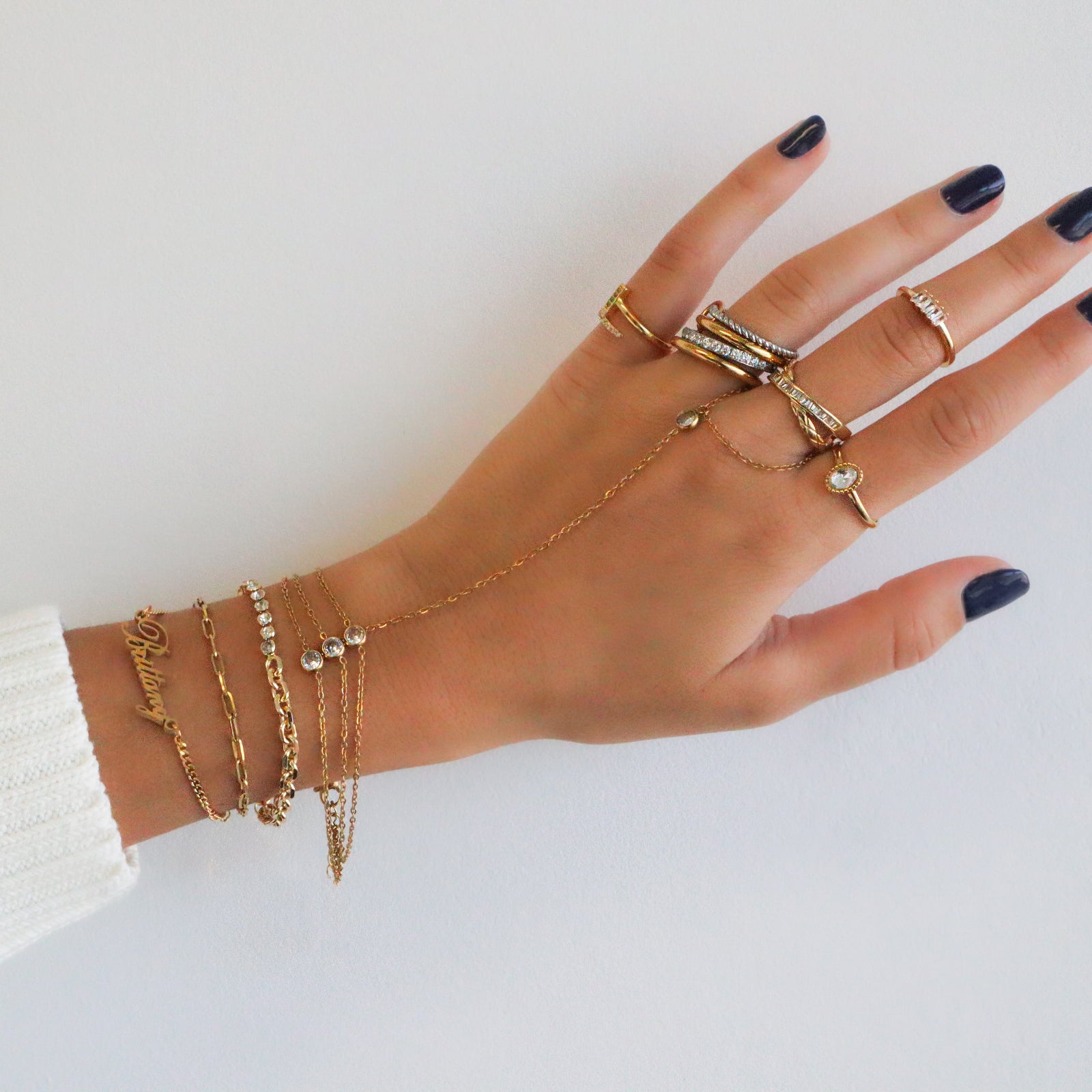 A detailed studio product shot of the Kouvr Zeina interlocking ring showing the pavé diamond and twisted rope bands.