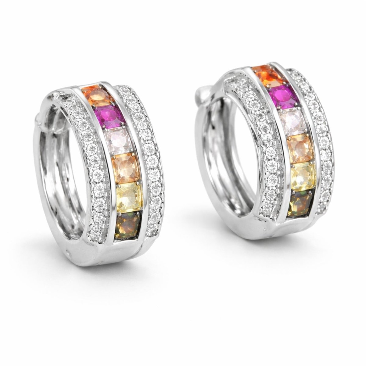 A pair of Kouvr Zinia rainbow sapphire and diamond huggie hoop earrings in 18k white gold on a clean white background, showing the channel-set multi-colored gemstones.