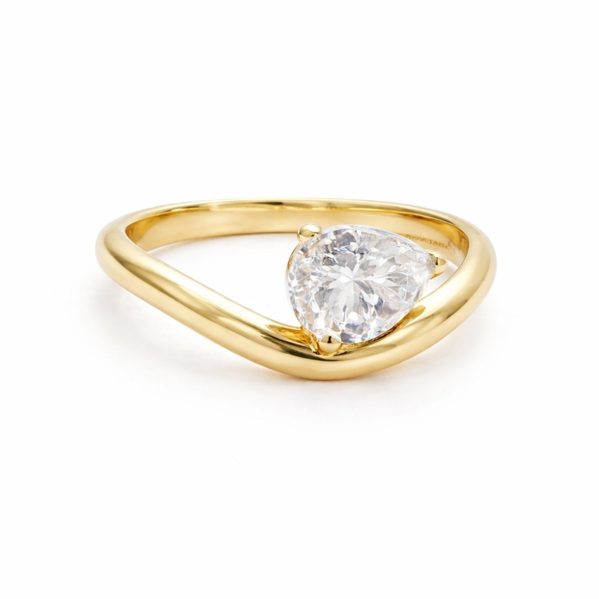 Kouvr Zoella 2 carat heart shaped diamond solitaire engagement ring in 18k yellow gold on a white background.