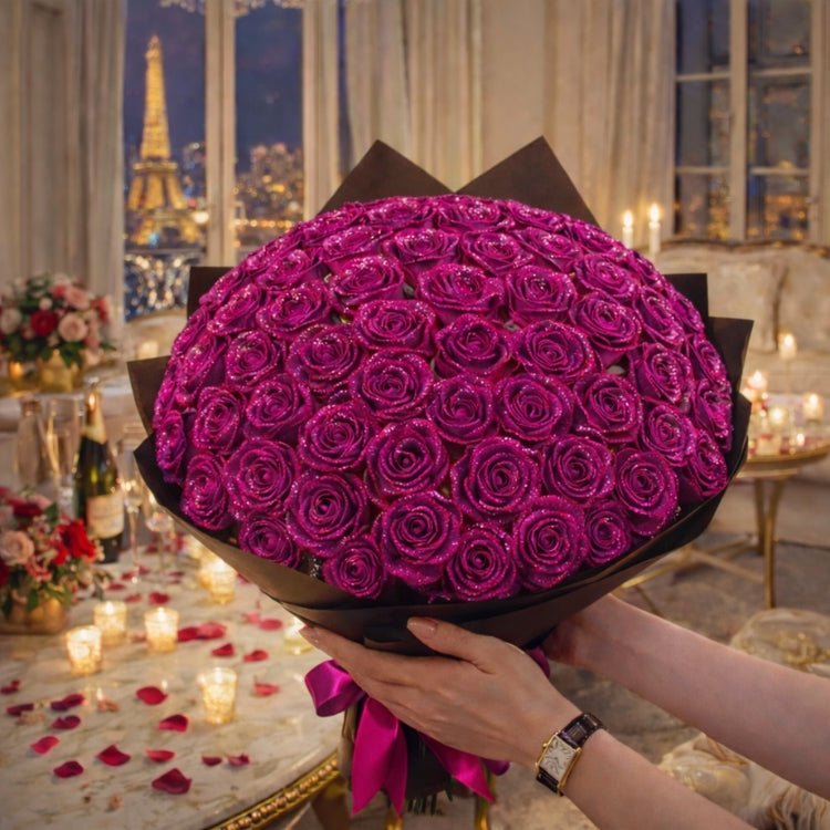 A large, premium bouquet of purple-magenta sparkle roses covered in glitter and wrapped in black paper, held against a luxury backdrop.