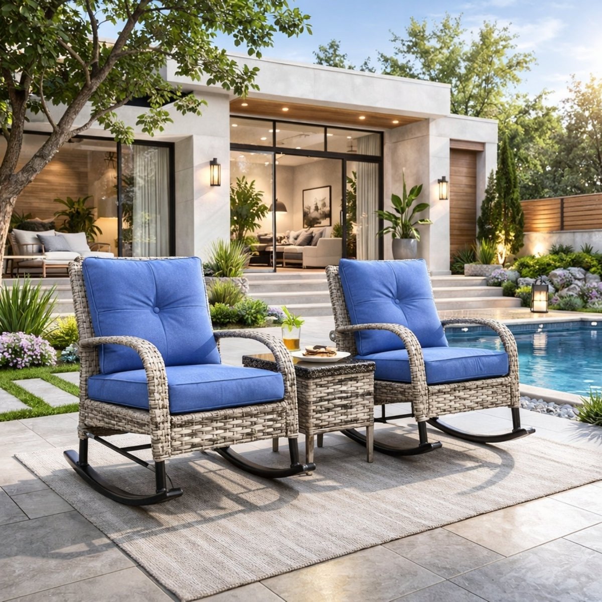Two all-weather rattan outdoor rocking chairs with plush navy cushions and bistro table arranged beside a luxury residential swimming pool.