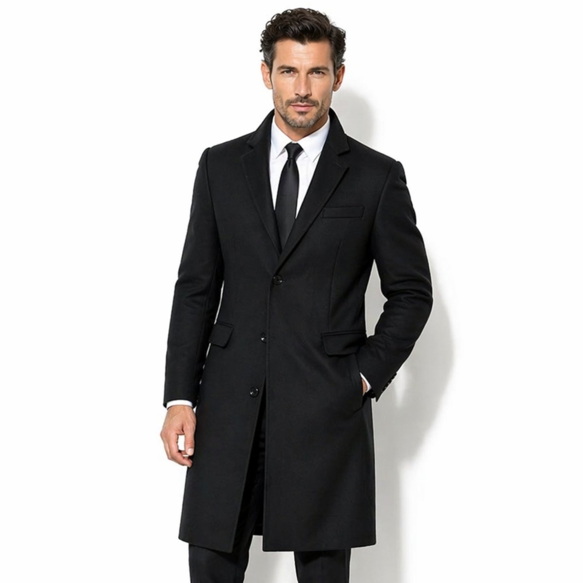 Front view of men's black single-breasted tailored wool overcoat by Kouvr, featuring a classic notch lapel and flap pockets over a white shirt and black tie.