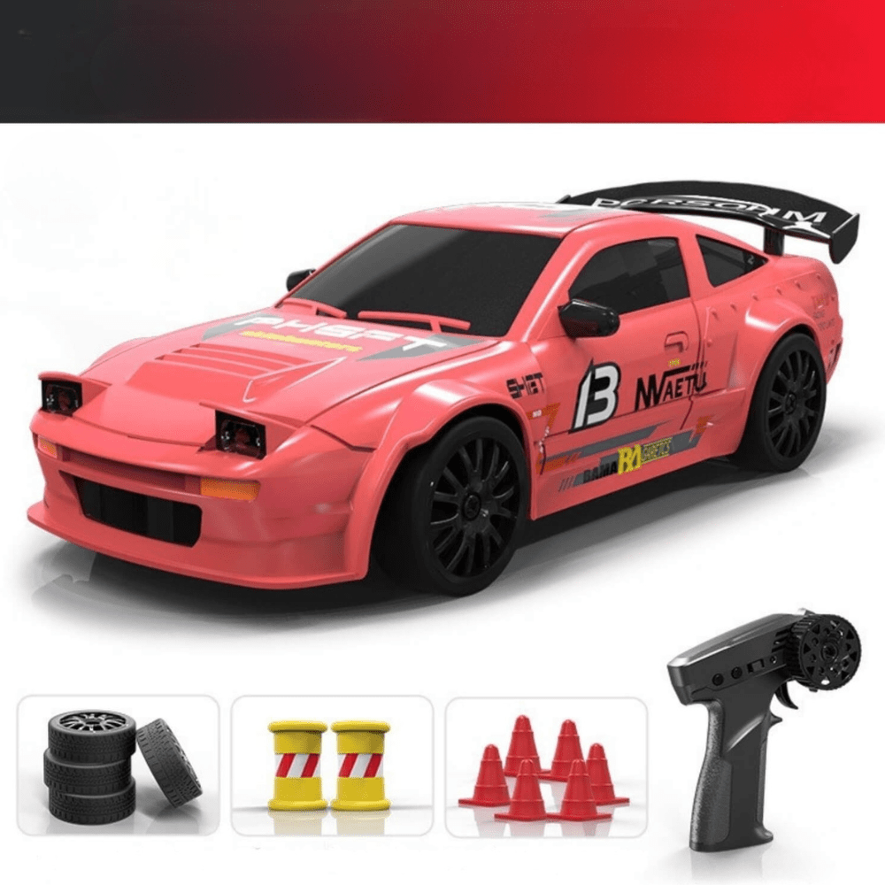 Pinkish-red drift RC car with racing decals and the number 13, displayed with a remote, spare tires, cones, and drums.