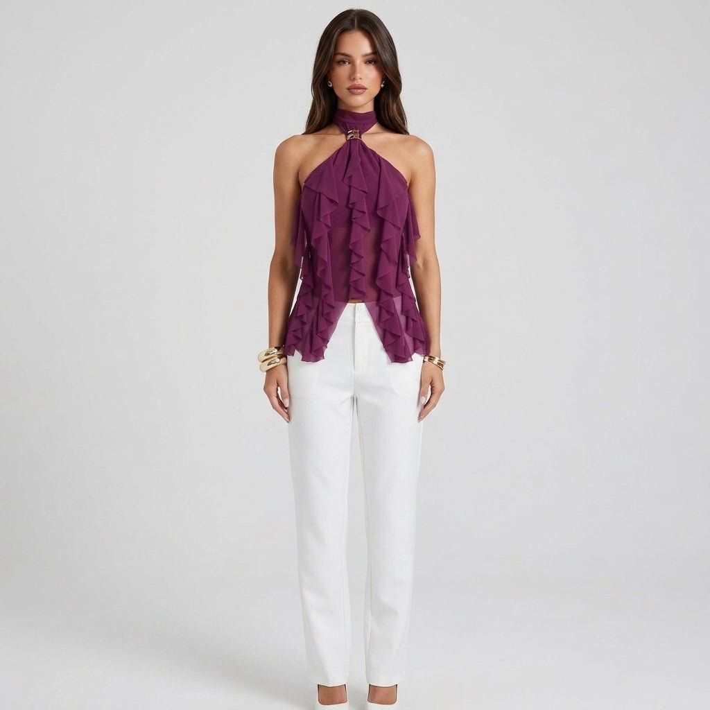 Full body studio shot of model in magenta sheer ruffle going out top paired with crisp white pants.
