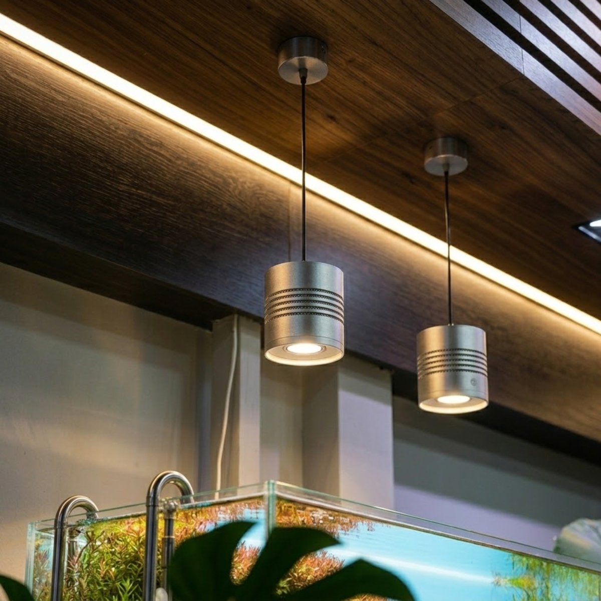 Close up of the premium silver milled aluminum Kouvr LED aquarium fixture showing the textured heat sink design and braided power cable.