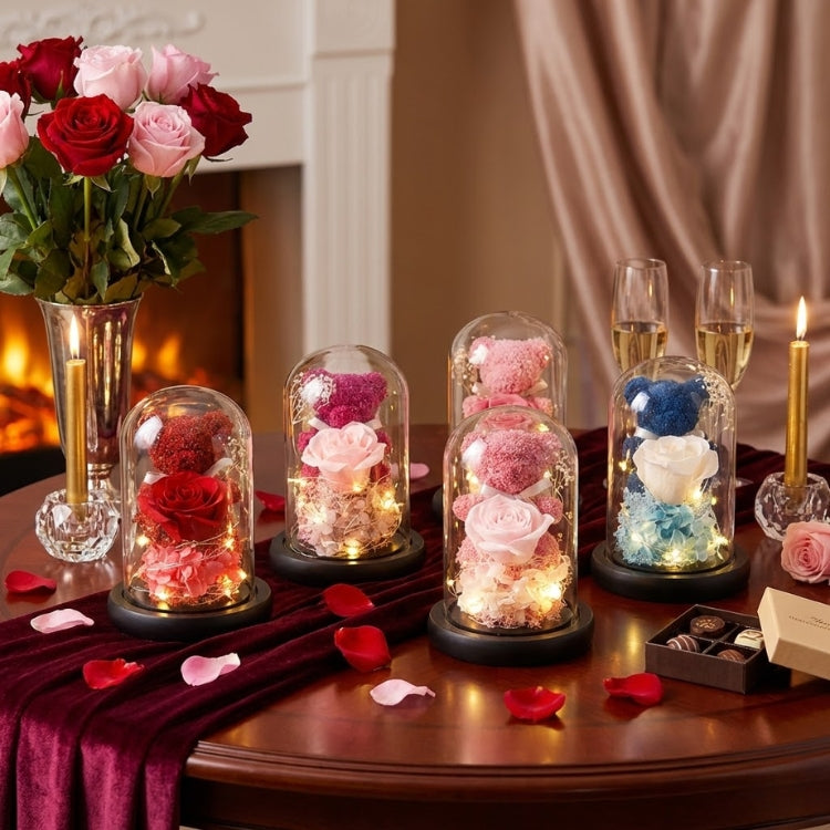 Three enchanted rose bears in purple, blue, and red sitting on decorative books with a fireplace and heart garland background.