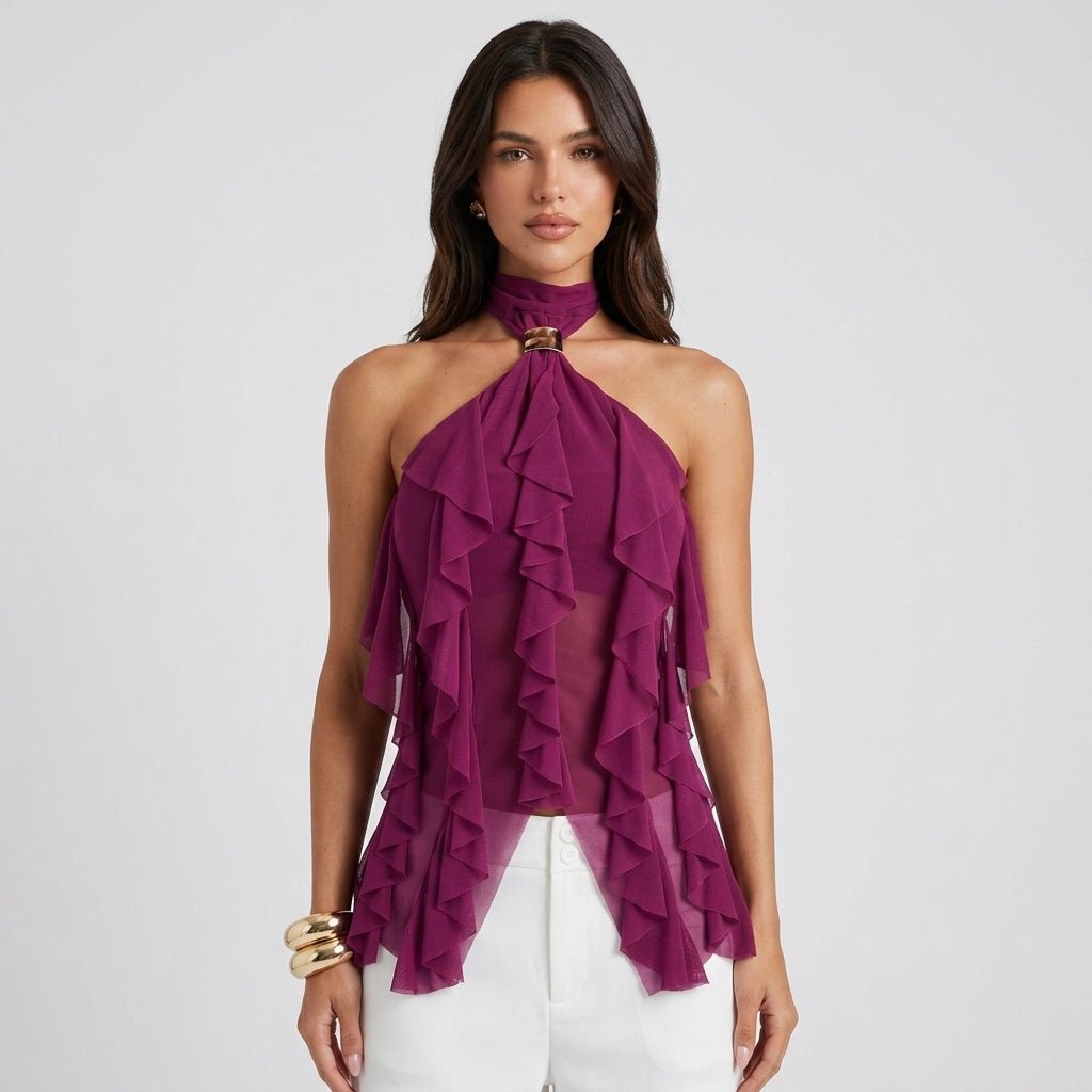 Woman wearing Kouvr purple cascading ruffle halter top with gold hardware and white trousers.