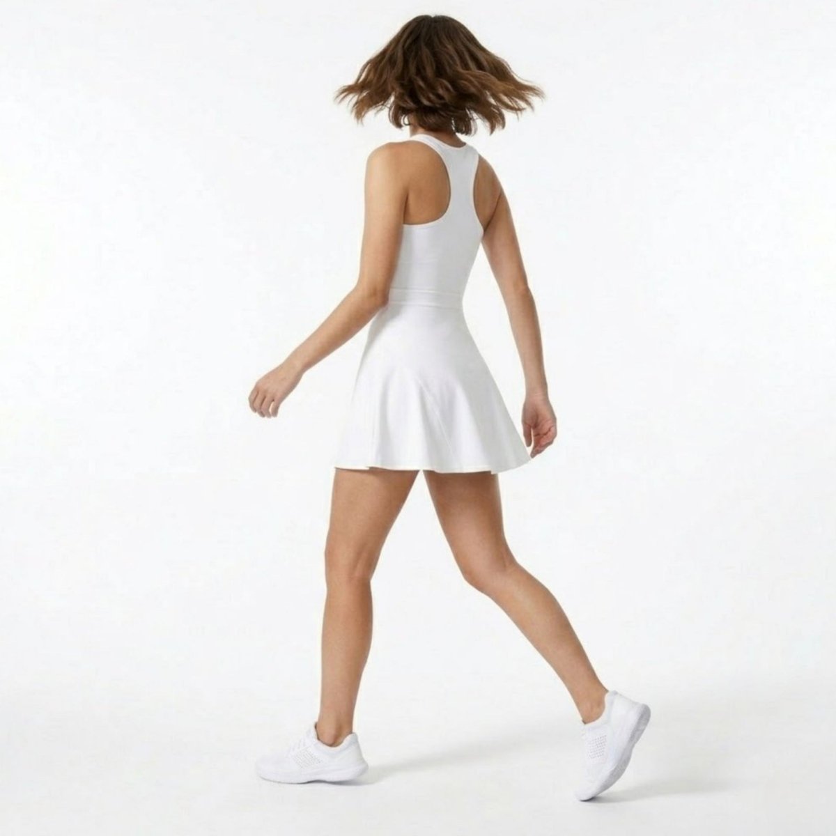 Back view showing the racerback design and flared skirt movement of the white premium activewear dress