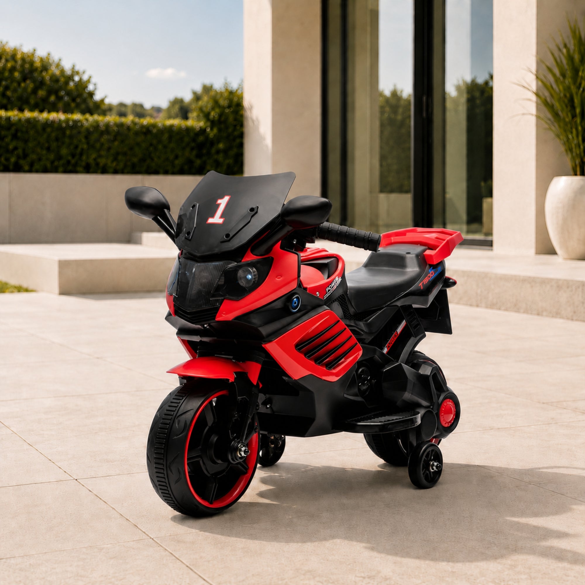 Red luxury kids 6V electric motorcycle with training wheels parked elegantly on an outdoor patio.