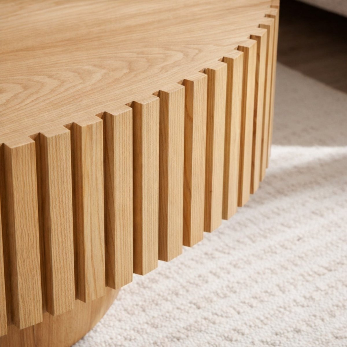 Close up detail of architectural ribbed wood edge on a light oak oval coffee table.