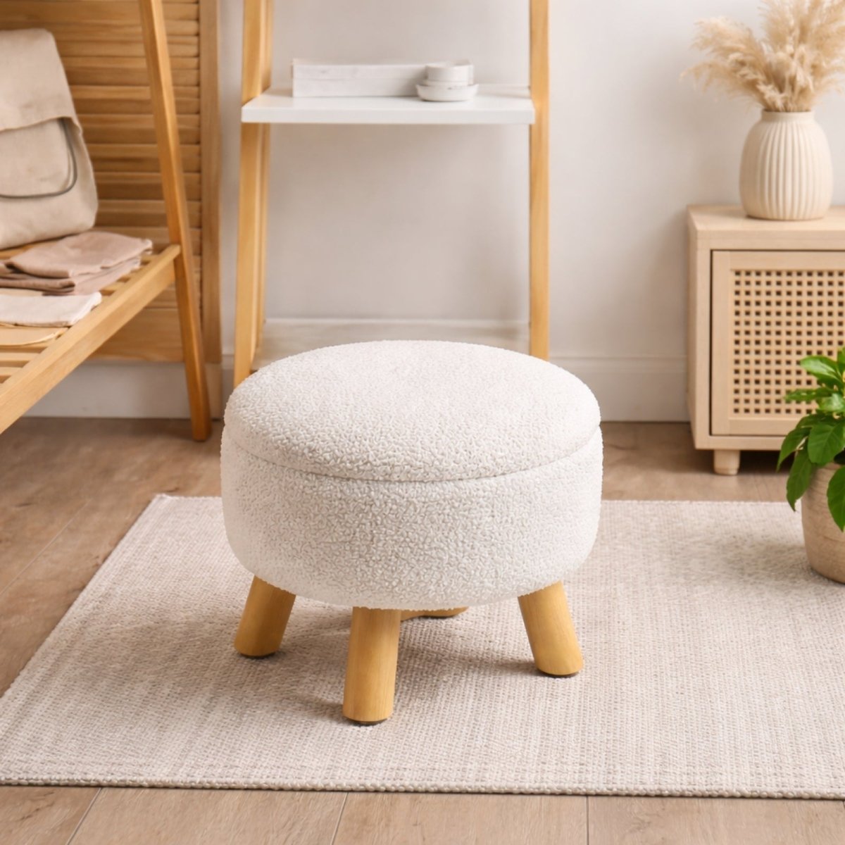 A round bouclé storage ottoman with the lid off, revealing a book stored inside, demonstrating its use as a functional accent stool.