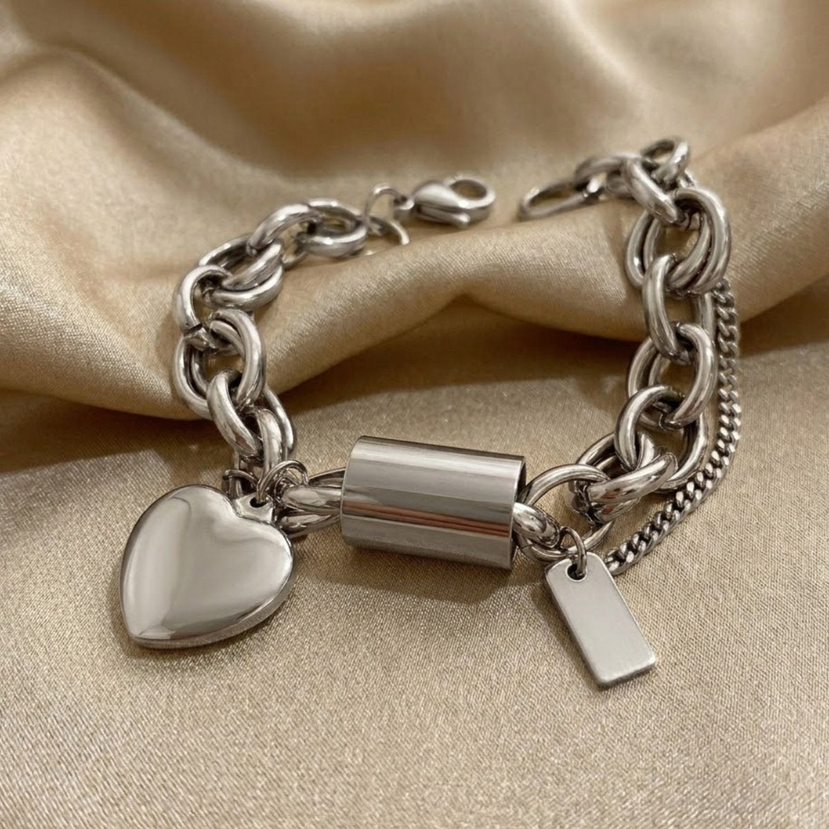 Silver chunky chain bracelet with heart charm and delicate safety chain detail, ideal for everyday wear.