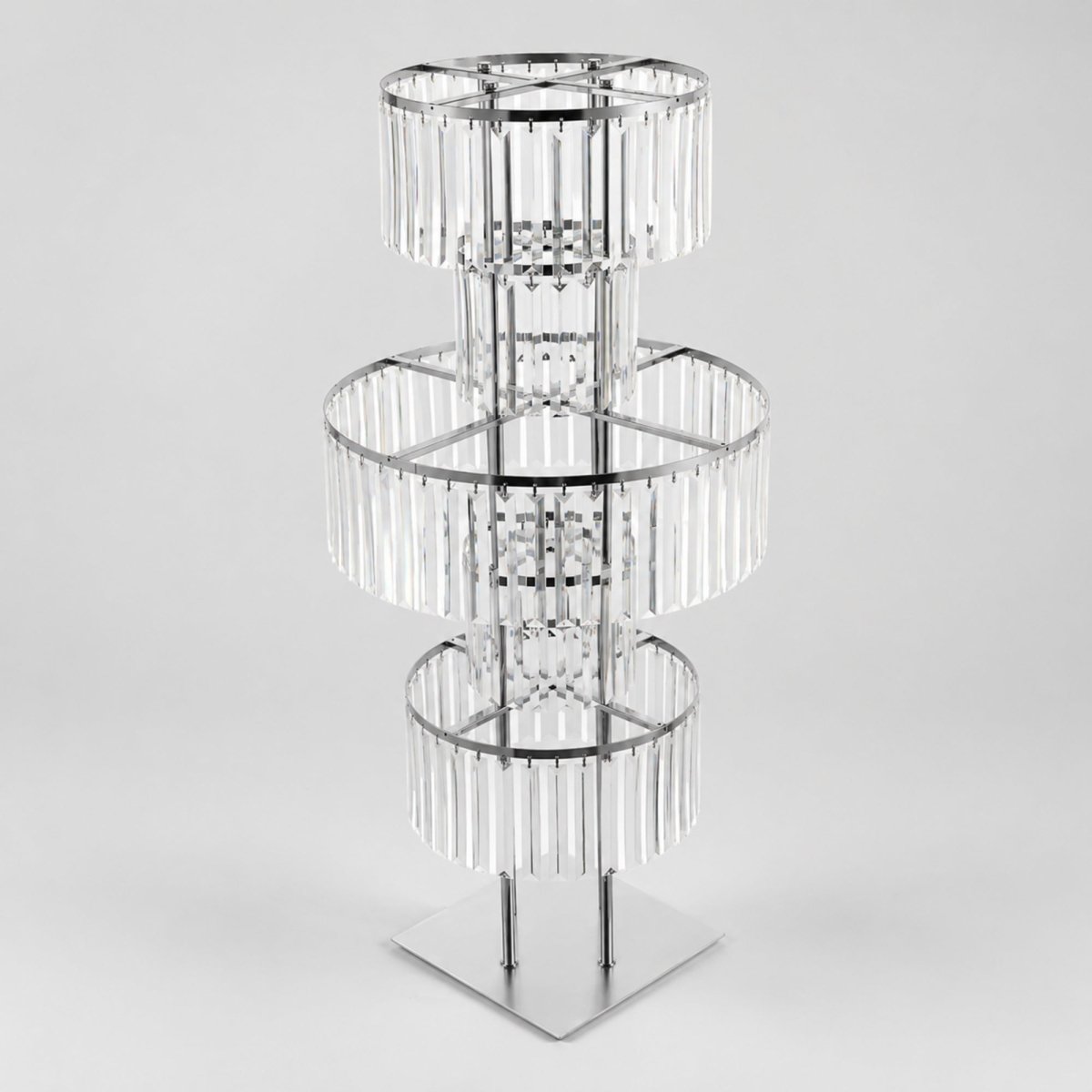 Studio product shot of an empty silver three-tier crystal acrylic event centerpiece stand showcasing clear hanging prisms.