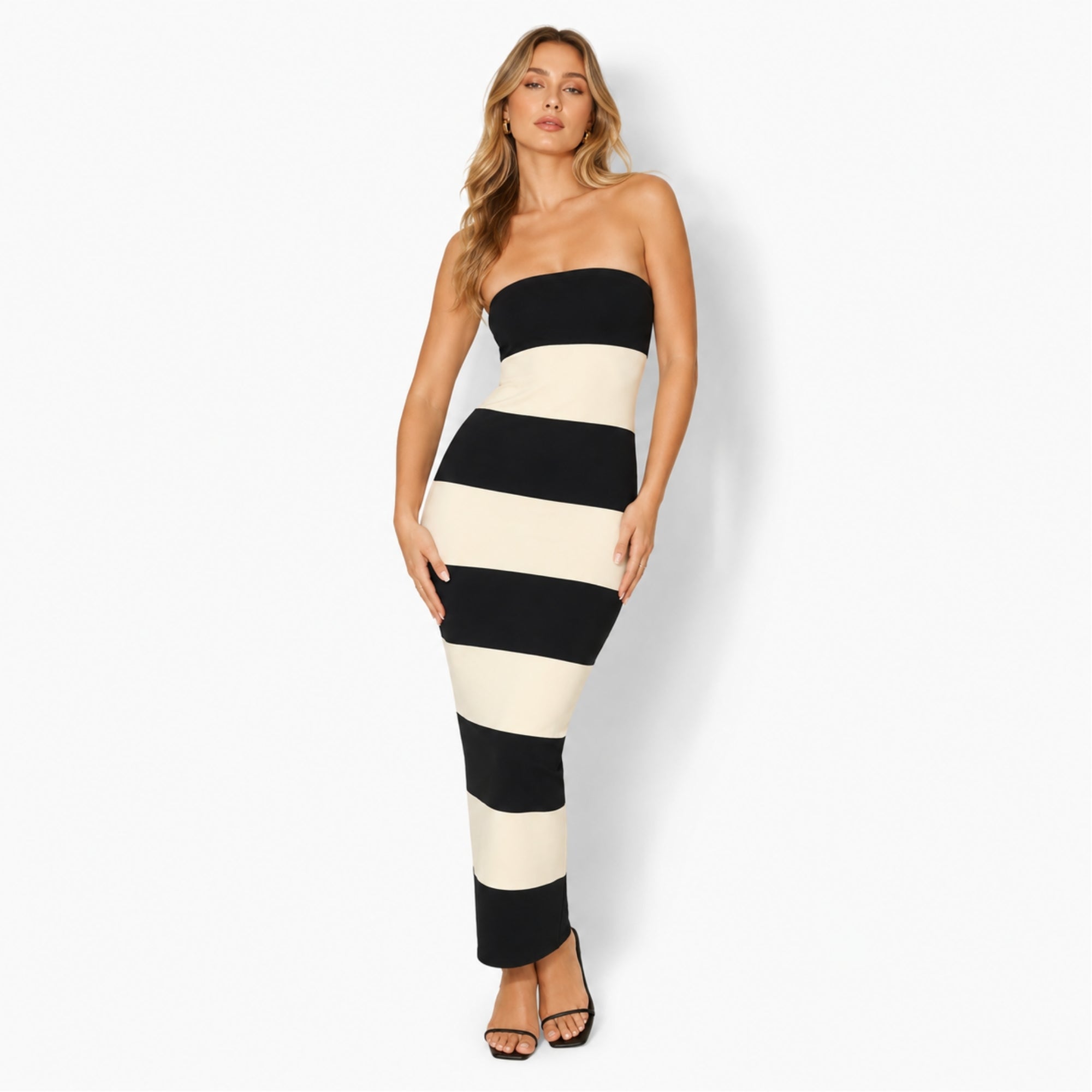 Front view of the Kouvr strapless black and white striped knit maxi dress on a blonde model showcasing the bodycon fit.