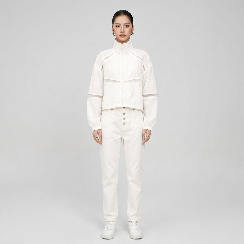 Full body studio shot of the white zip up athleisure jacket styled with matching high waisted denim