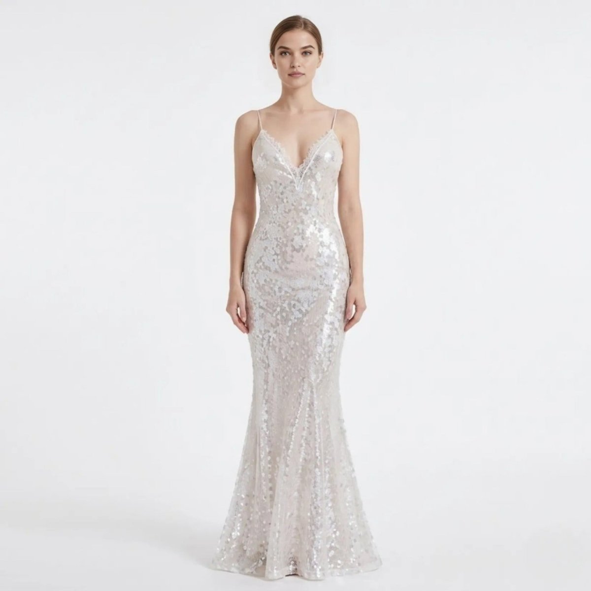 Front view of a female model wearing a luxurious white sequin V-neck mermaid evening gown by Kouvr, featuring a floor-length sweeping hem.