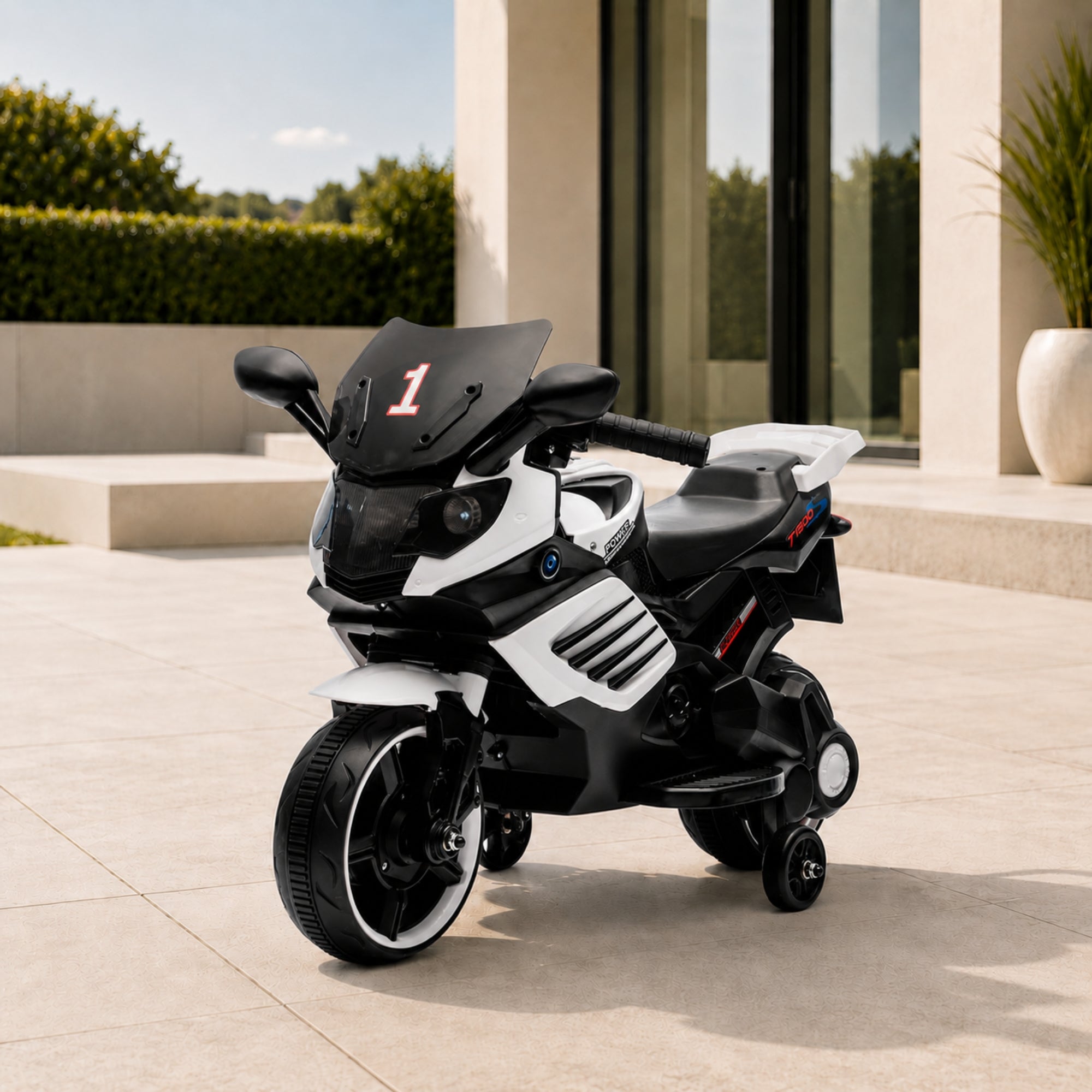 White luxury kids 6V electric motorcycle with training wheels parked elegantly on an outdoor patio.