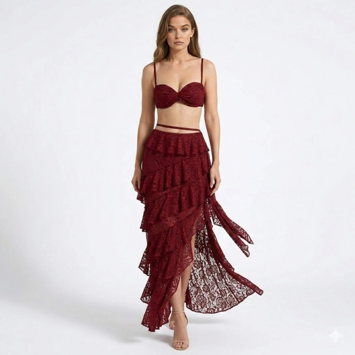 Woman walking wearing a wine red lace two piece set featuring a sweetheart bustier crop top and an asymmetrical tiered ruffle maxi skirt by Kouvr.