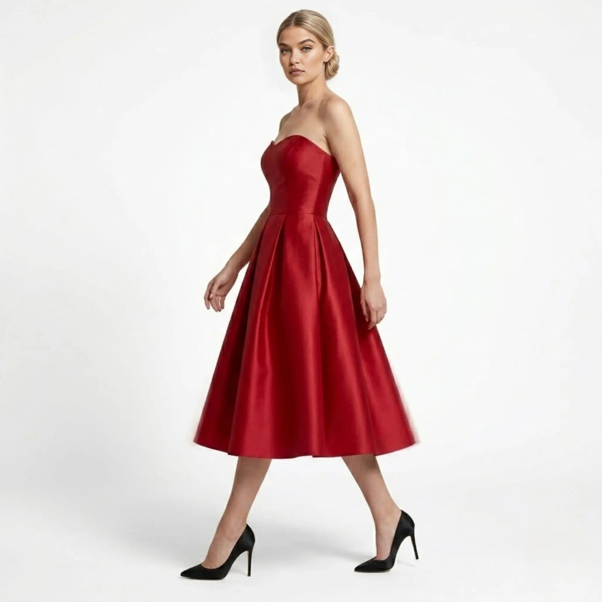 Side profile view of walking model in elegant wine red strapless A-line midi party dress with structured pleated skirt