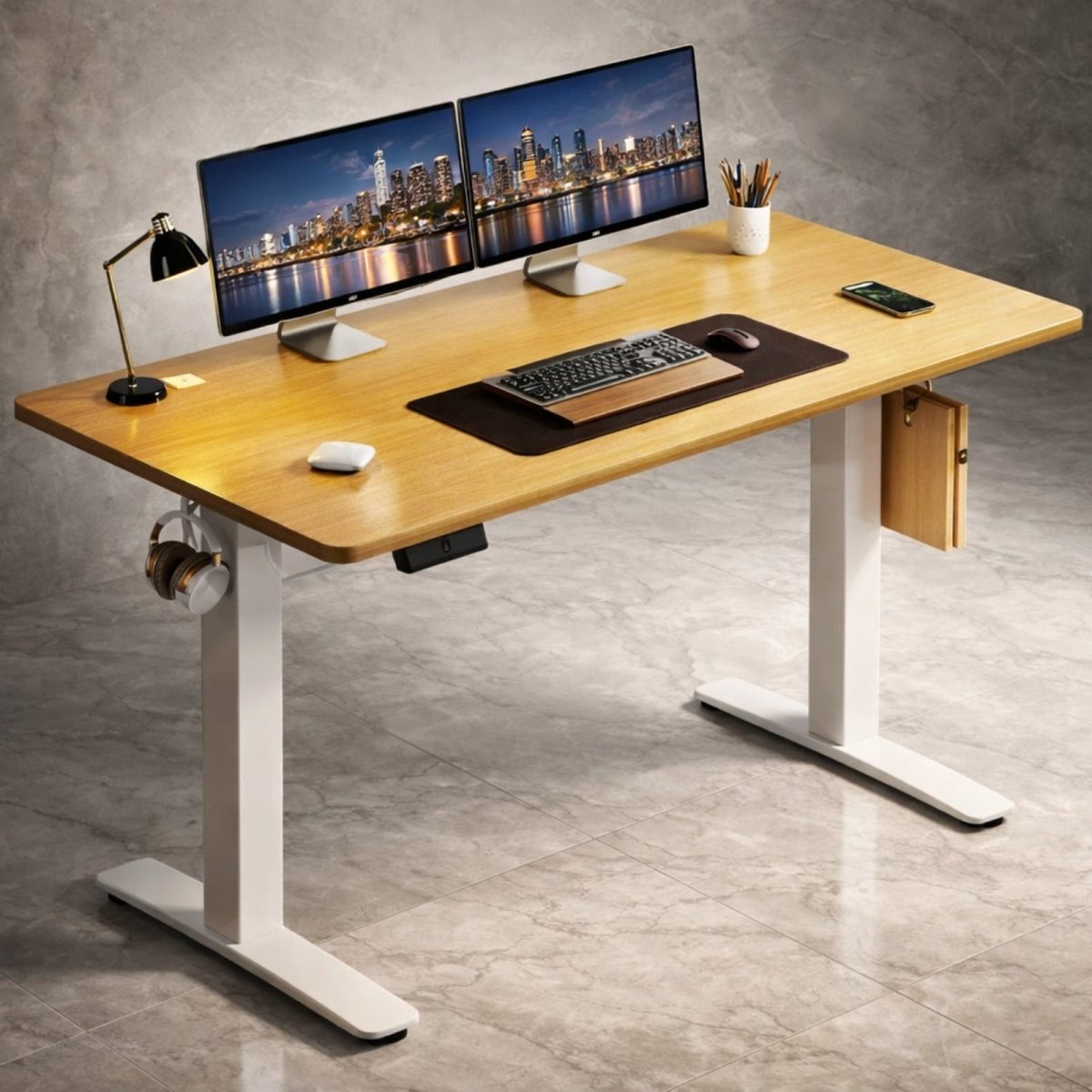 A woman sitting comfortably at the Kouvr natural oak standing desk in a home office with a city view, demonstrating its ergonomic use with a laptop and monitor.