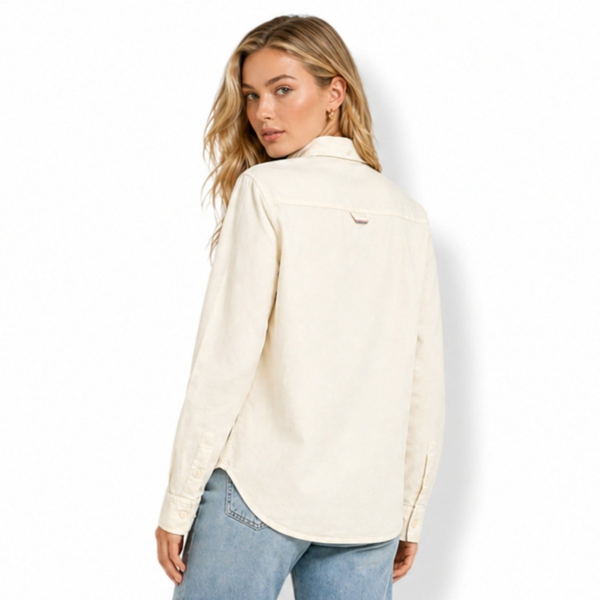 Back view of a women's beige cotton shacket highlighting the curved hemline, structured upper yoke, and subtle loop tag detail.
