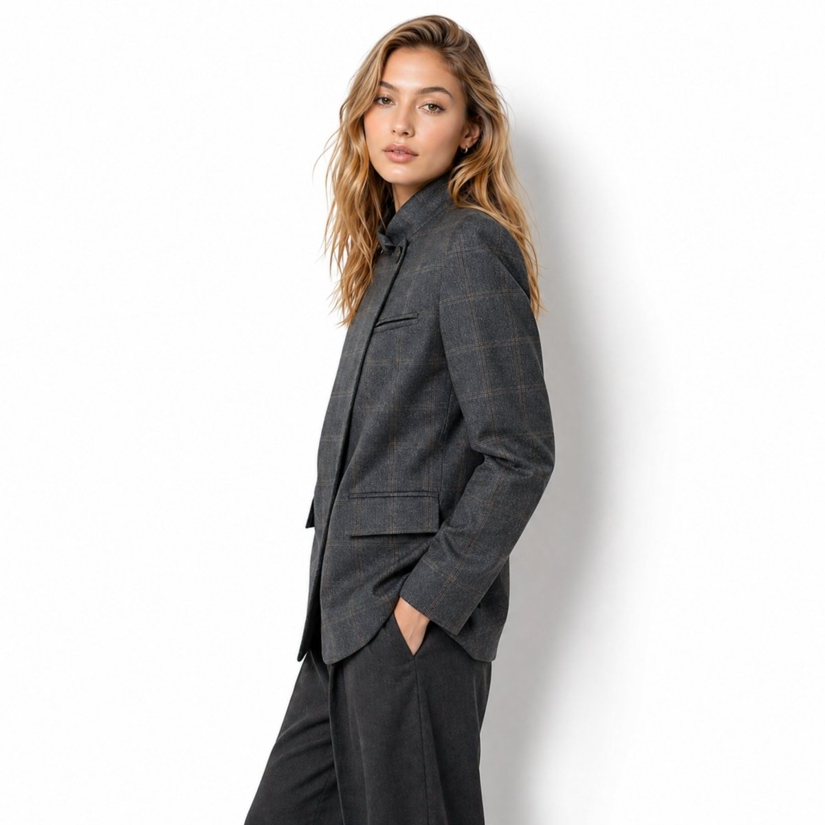 Side profile of female model showcasing the structured fit and windowpane check pattern of the Kouvr grey blazer.