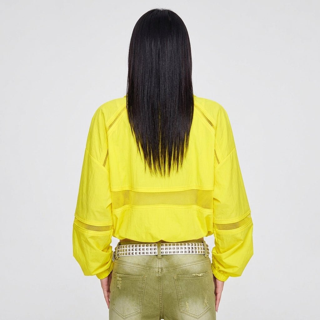 Back view of women's yellow athleisure zip-up jacket showing horizontal mesh inset details and elastic hem.