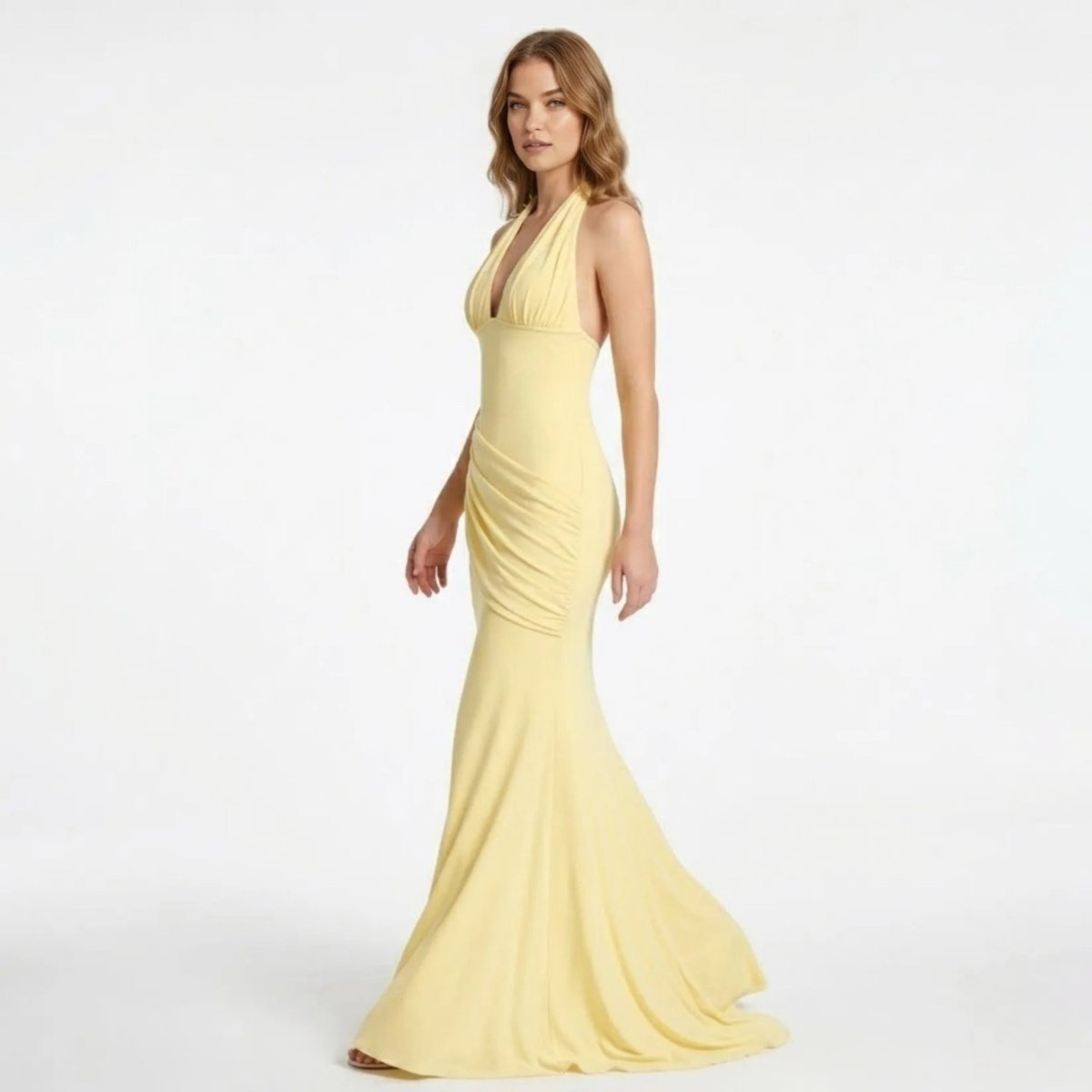 Side profile of the Kouvr yellow formal maxi dress highlighting the asymmetrical ruched hip detailing and elegant fitted silhouette.