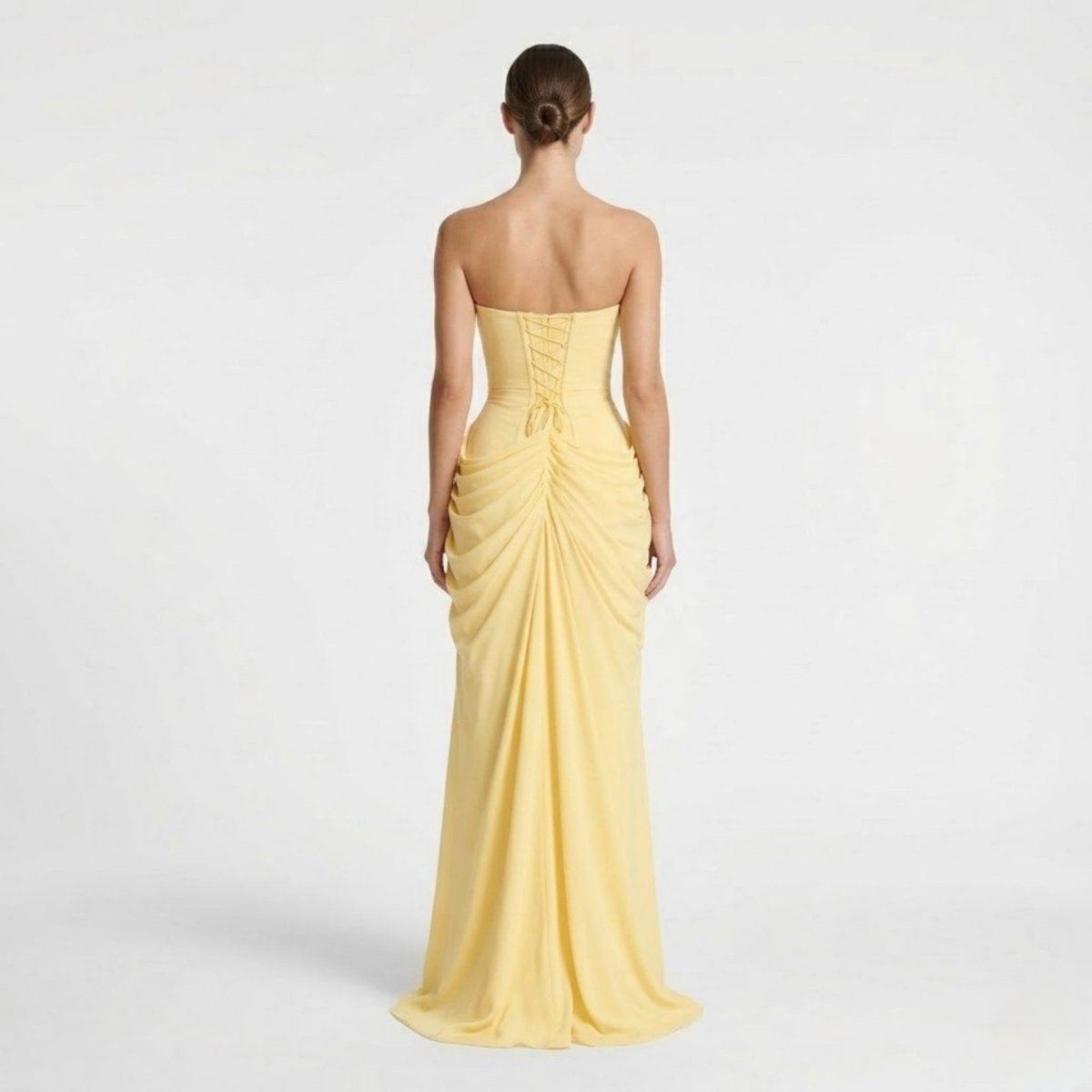 Back view of yellow maxi dress featuring adjustable lace-up corset back and soft draped flowing skirt.