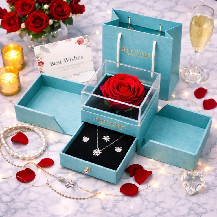Luxury turquoise jewelry organizer with a clear acrylic top displaying a large red rose and a bottom drawer holding a crystal starburst necklace and stud earrings on a marble table.