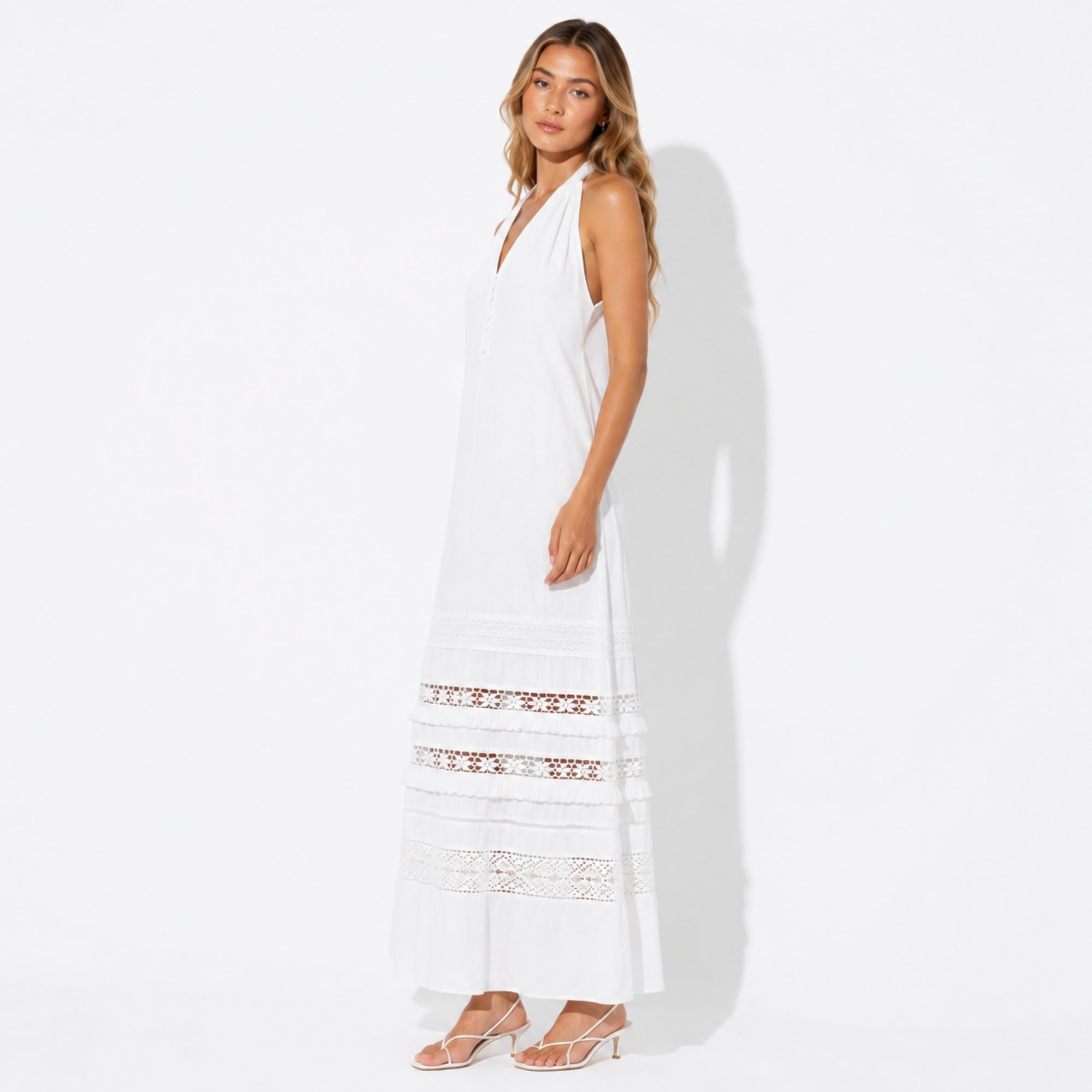 Side view of the elegant white sleeveless summer maxi dress showing sheer lace panel details and drape.